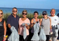 Volunteers hold bags of trash collected from the beach.